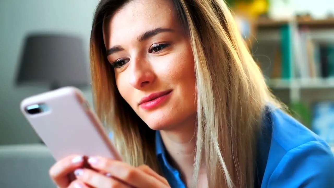 Woman using smartphone for TeleOrthodontics consultation, showcasing convenient communication for orthodontic care.